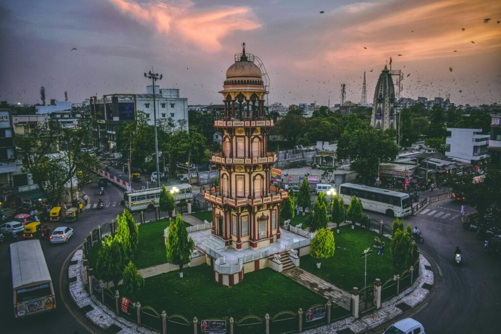 Aerial view of a historic tower in Ahmedabad, India at dusk surrounded by urban cityscape.