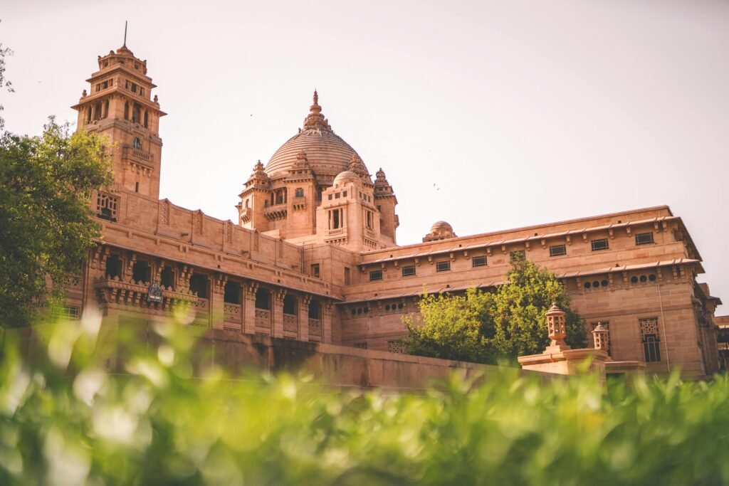 Majestic Umaid Bhawan Palace in Jodhpur, India, captured in daylight with lush greenery.